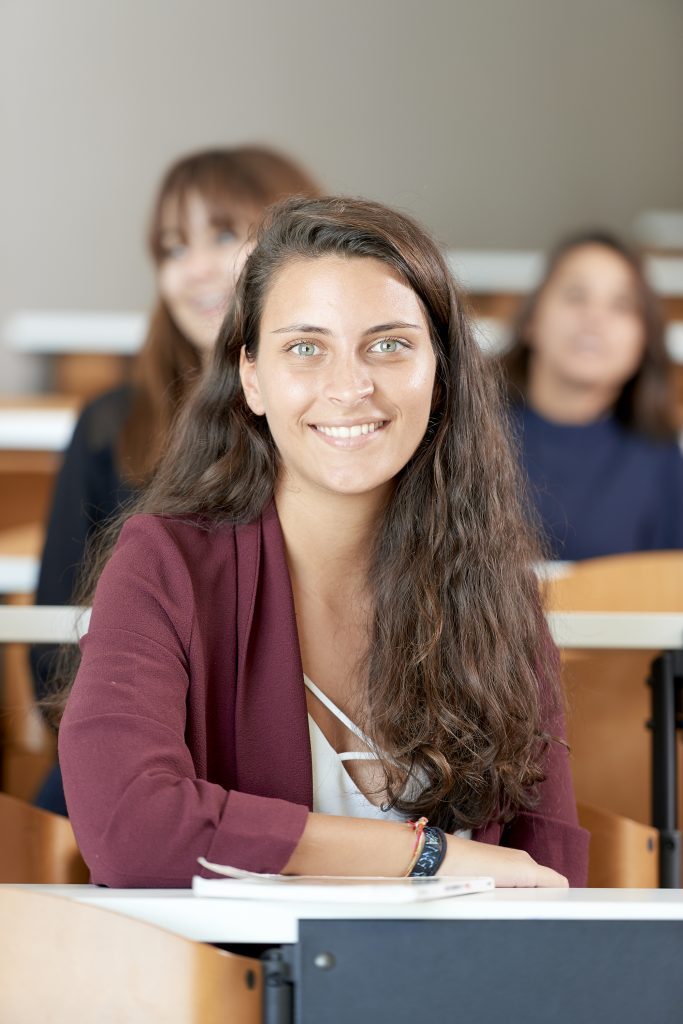 student at the inseec business school smiling in a lecture hall