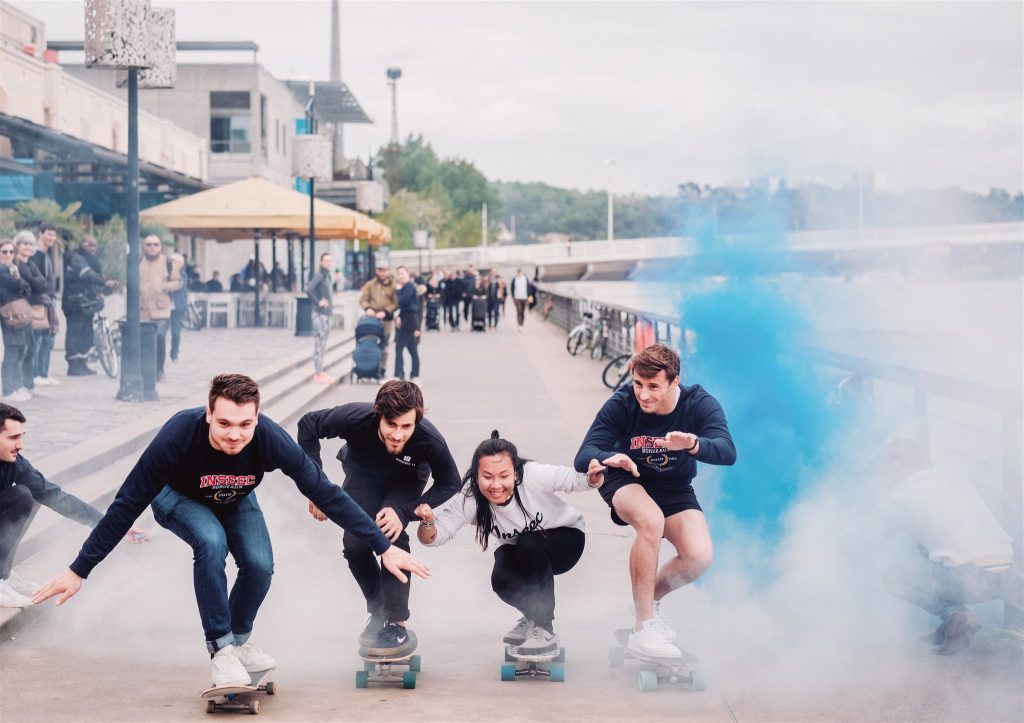 students playing sports and skating with blue inseec smokes