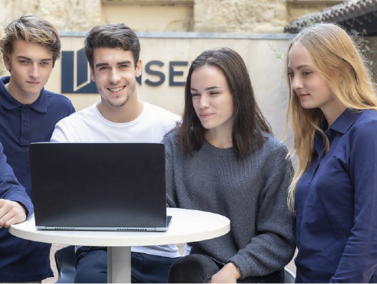 Group of students looking at a laptop for a project in finance