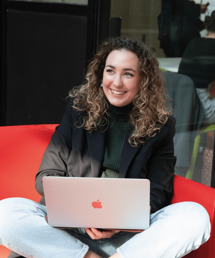 INSEEC Bachelor student sitting on a sofa working on her computer