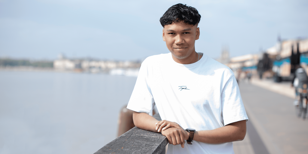 student of the INSEEC business school installed outside and leaning on a fence along the river