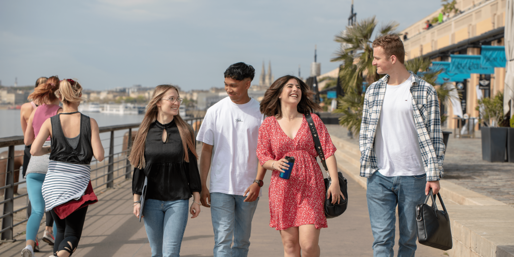 five students from the INSEEC business school walking outside and laughing