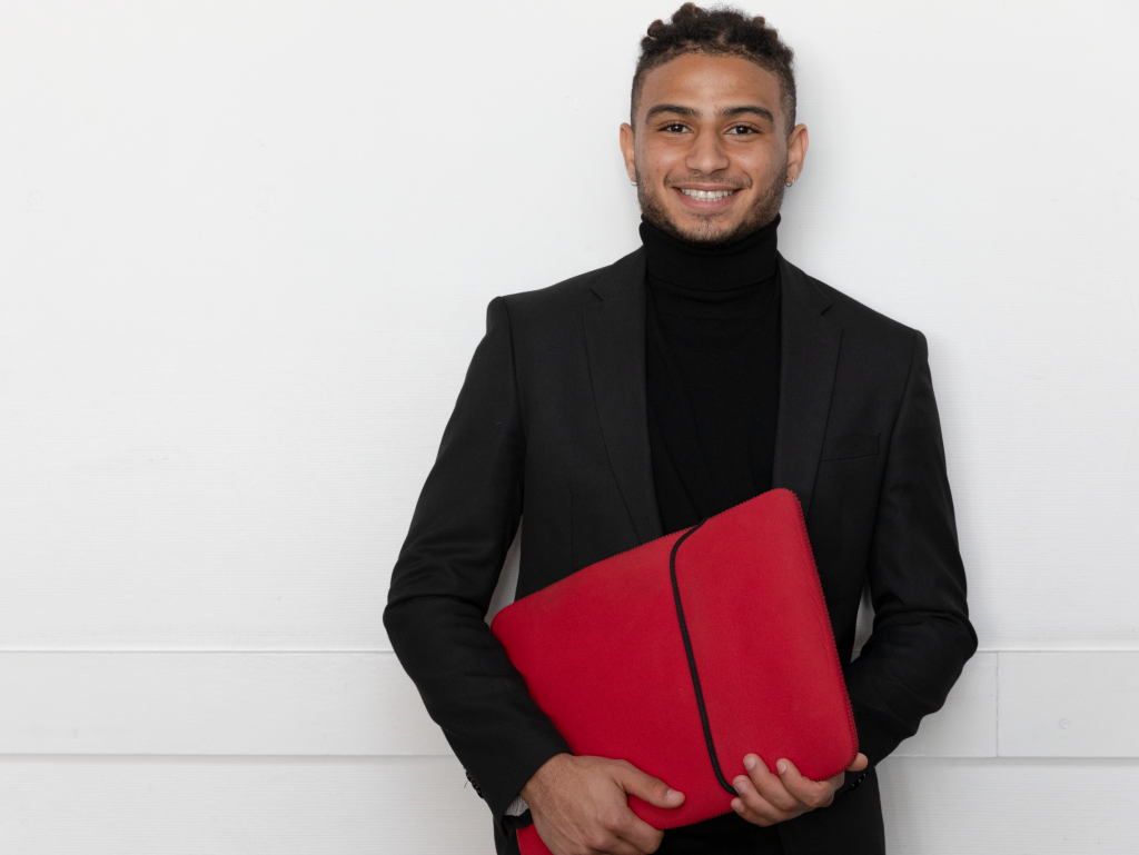 INSEEC business school student holding a computer case and smiling