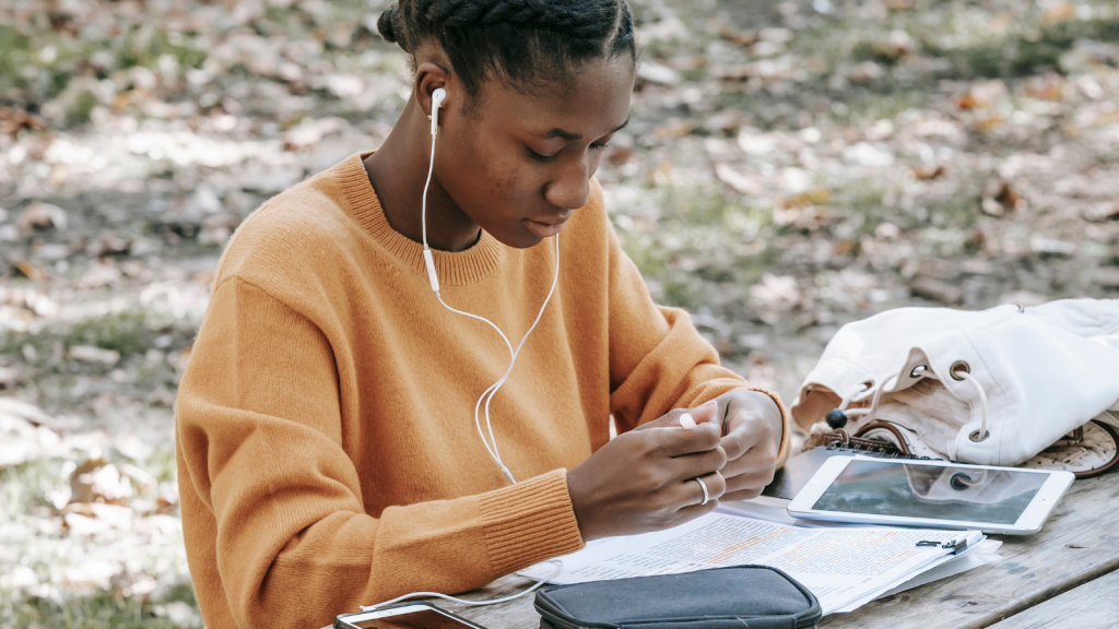 Student of the inseec grande ecole sitting on a bench while working