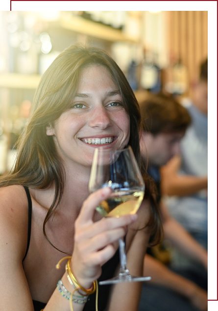une etudiante qui déguste un verre de vin