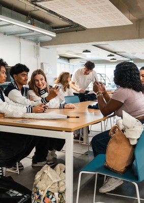 Groupe d’étudiants assis autour d’une table dans la cafétéria du campus de Bordeaux de l’école de commerce INSEEC