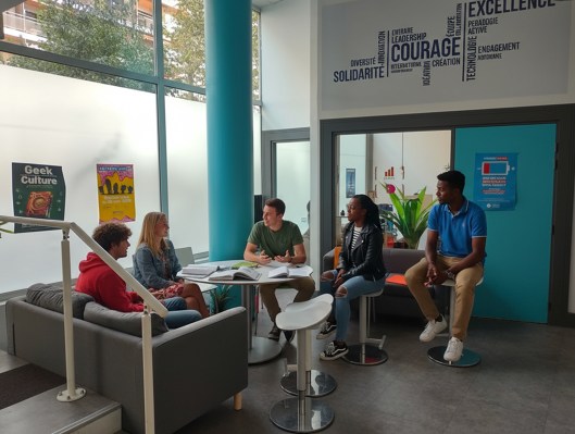 Groupe d’étudiants discutant dans le hall du campus de Marseille de l’école de commerce INSEEC