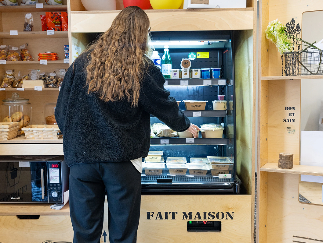 Étudiante choisissant un sandwich dans un distributeur de la cafétéria du campus de Rennes de l’école de commerce INSEEC