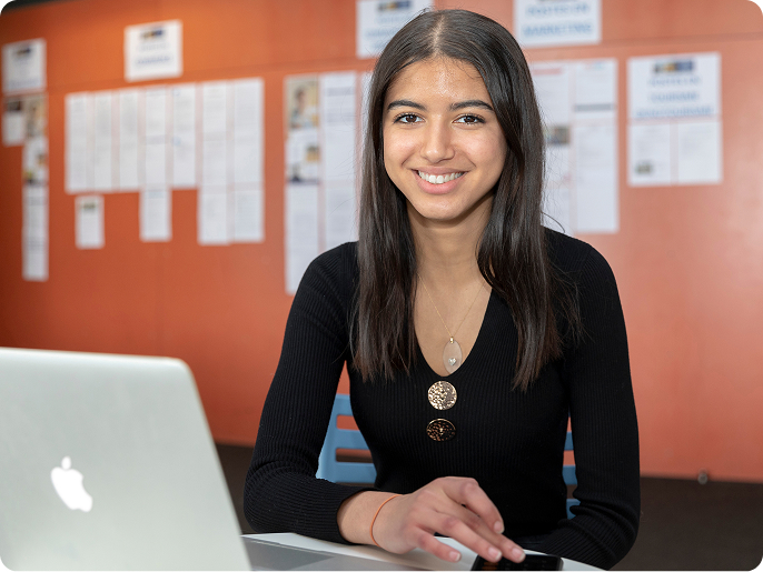 Étudiante souriante devant un ordinateur