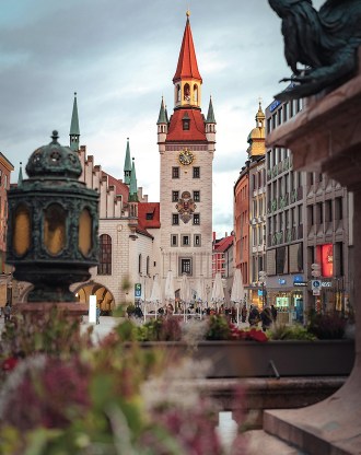 Vue sur l’Ancienne Halle au Poisson de Munich et sa tour à horloge, entourée de bâtiments colorés en centre-ville