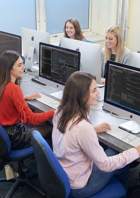 Étudiants travaillant sur des iMac dans une salle informatique du campus OMNES Education à Londres, lors d’un cours de programmation