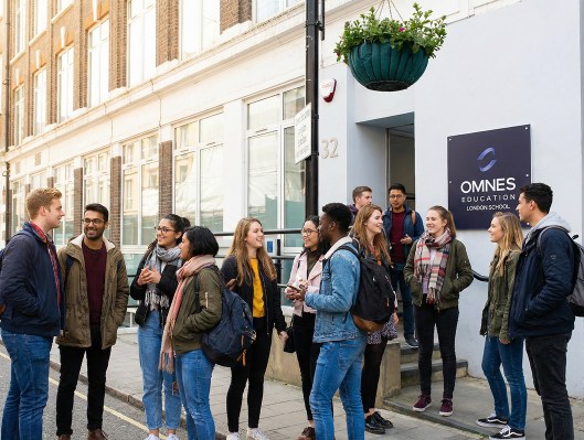 Étudiants sortant du campus OMNES Education de Londres, devant la façade vitrée d’un immeuble londonien