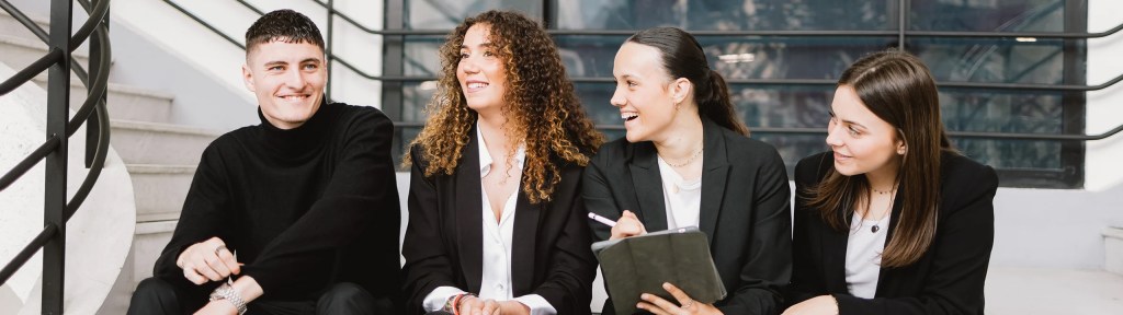 Photo d’illustration d’étudiants en costard assis sur des marches de l’escalier du campus de Lyon de l’école de commerce INSEEC