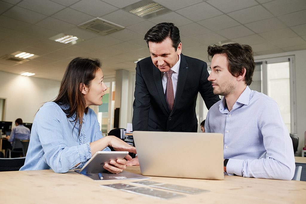 un consultant en ressources humaines accompagne 2 professionnels dans un bureau