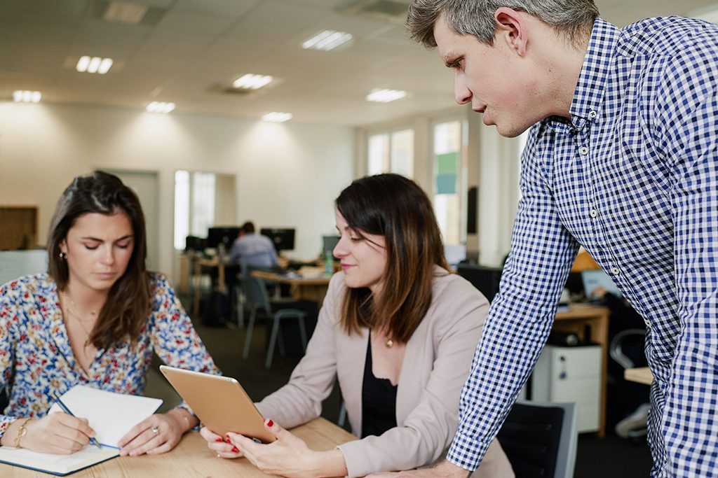 3 young INSEEC graduates around a table discussing their future international plans