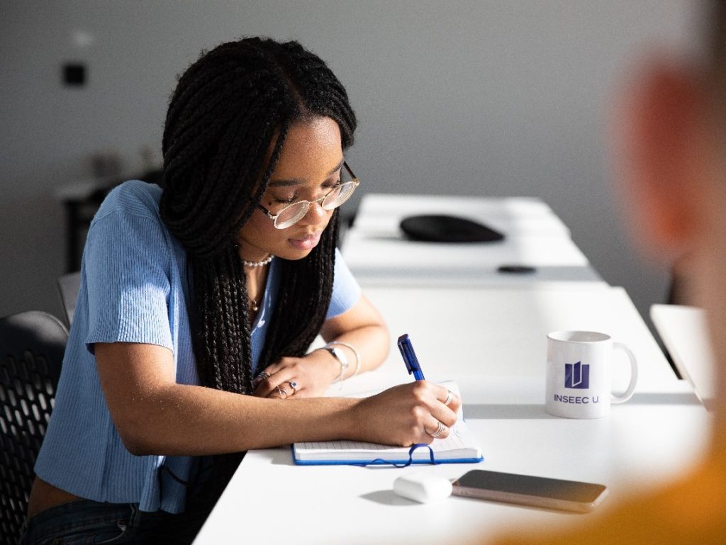 INSEEC student taking notes during a class  