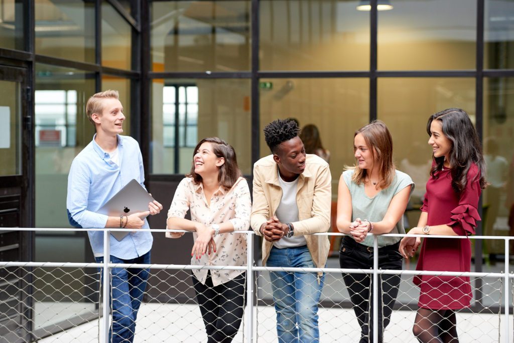 Students discussing their finance education in the corridors on the Lyon campus  