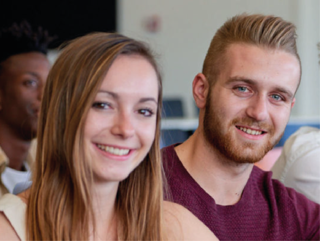 2 étudiants en cours qui sourient. 