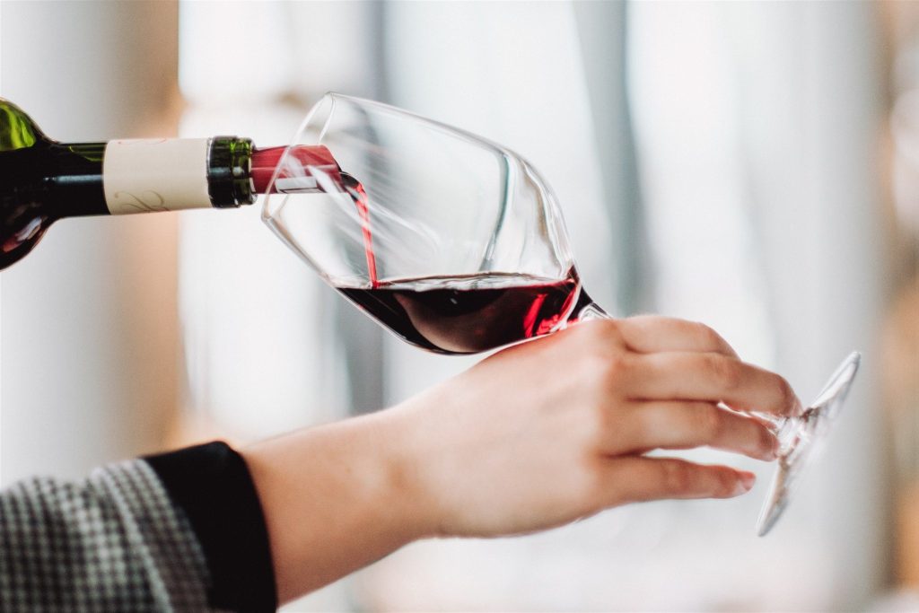 Amandine LAROCHE's hand serving a glass of wine during an INSEEC event