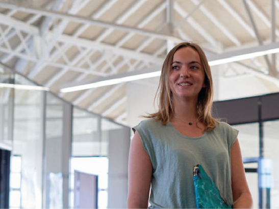 A student on the Lyon campus who has just finished her training in international finance and is holding her laptop.  