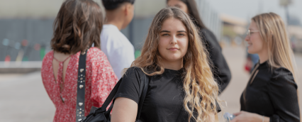 étudiante de l'école de commerce INSEEC se trouvant en extérieur à côté d'autres étudiants