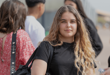 étudiante de l'école de commerce INSEEC se trouvant en extérieur à côté d'autres étudiants