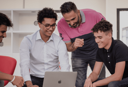 étudiants de l'école de commerce INSEEC assis autour d'un ordinateur pour travailler