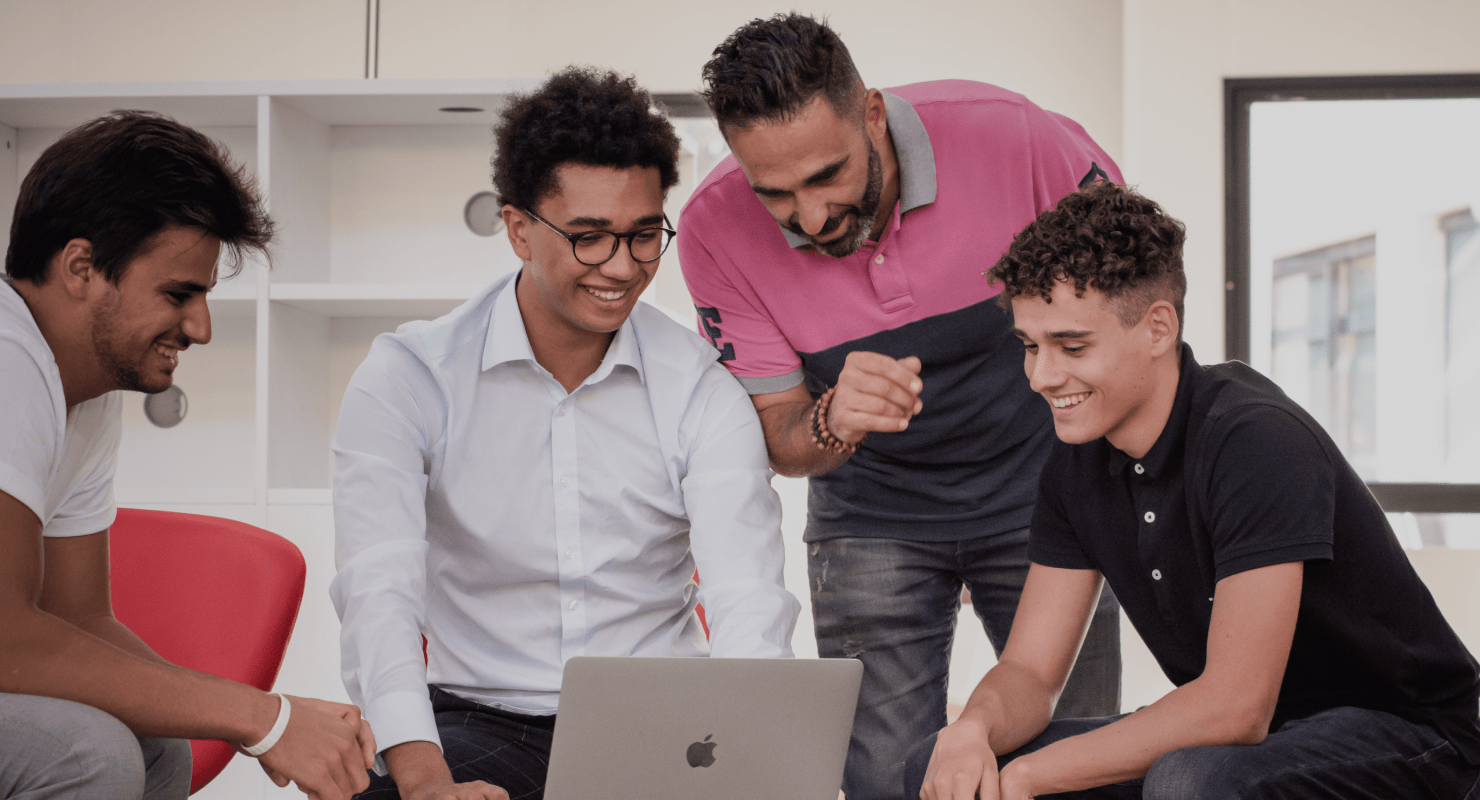 étudiants de l'école de commerce INSEEC assis autour d'un ordinateur pour travailler