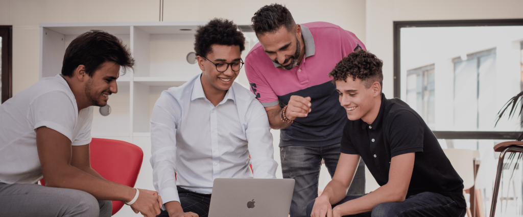 étudiants de l'école de commerce INSEEC assis autour d'un ordinateur pour travailler