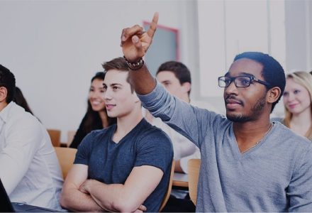 Student raises hand in purchasing and supply chain class