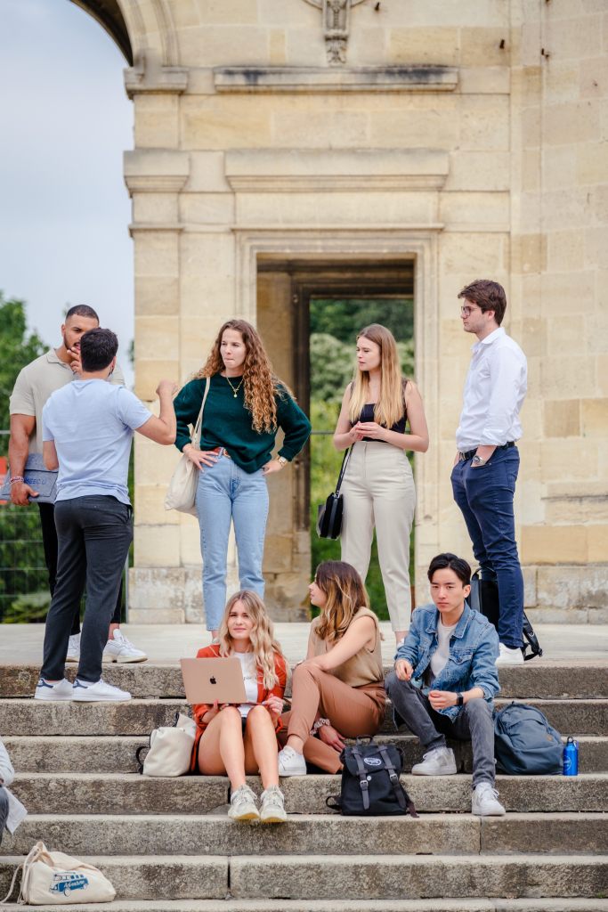 Etudiants INSEEC travaillant en extérieur sur leur projet de groupe 