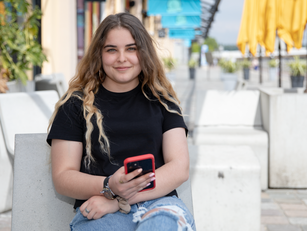 student of the INSEEC Bachelor business school holding her smartphone  