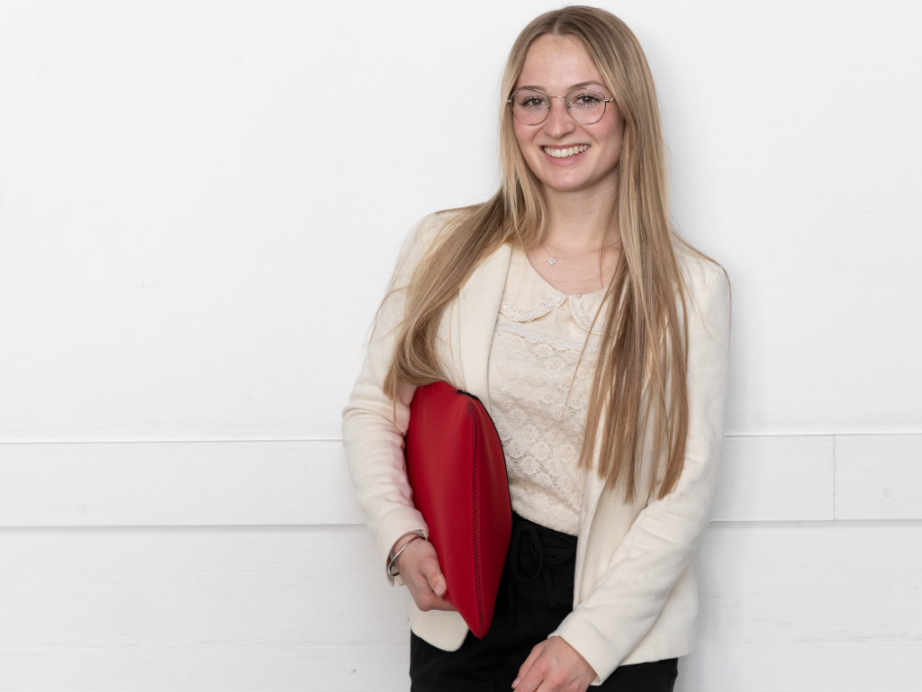 student of the INSEEC business school carrying a computer bag and smiling  