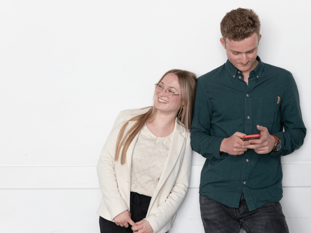 two students from the INSEEC business school leaning against each other and laughing