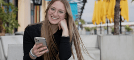 Student smiling with her phone in hand