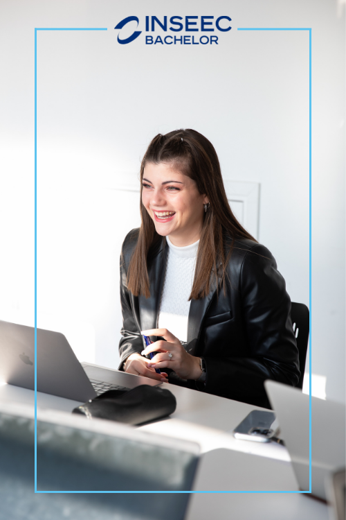 une étudiante du programme Bachelor de l'INSEEC est souriante devant son ordinateur