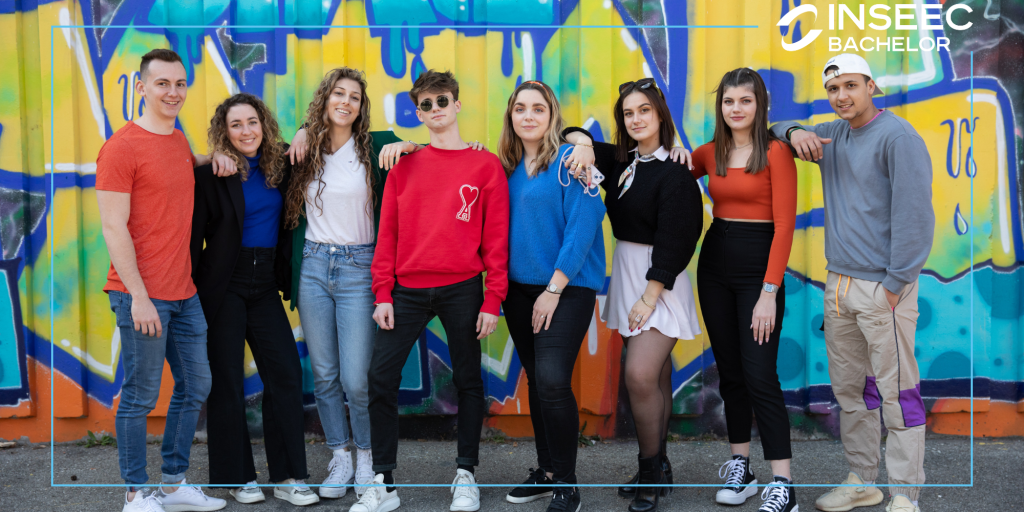 étudiants du programme Bachelor de l'école de commerce INSEEC en rang devant un mur rempli de graffitis 