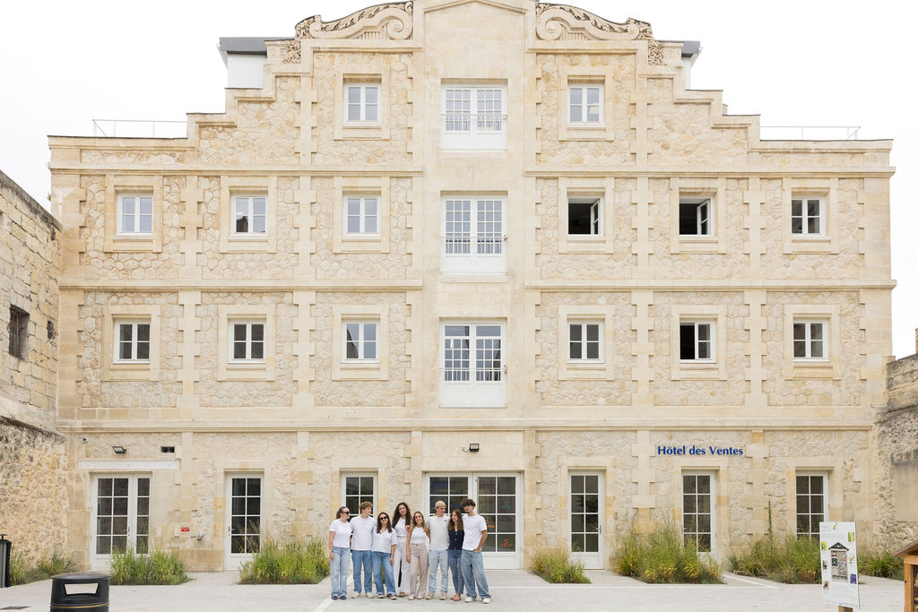 Photo de la façade du 136 quai des Chartrons, bâtiment du campus INSEEC de Bordeaux avec des étudiants